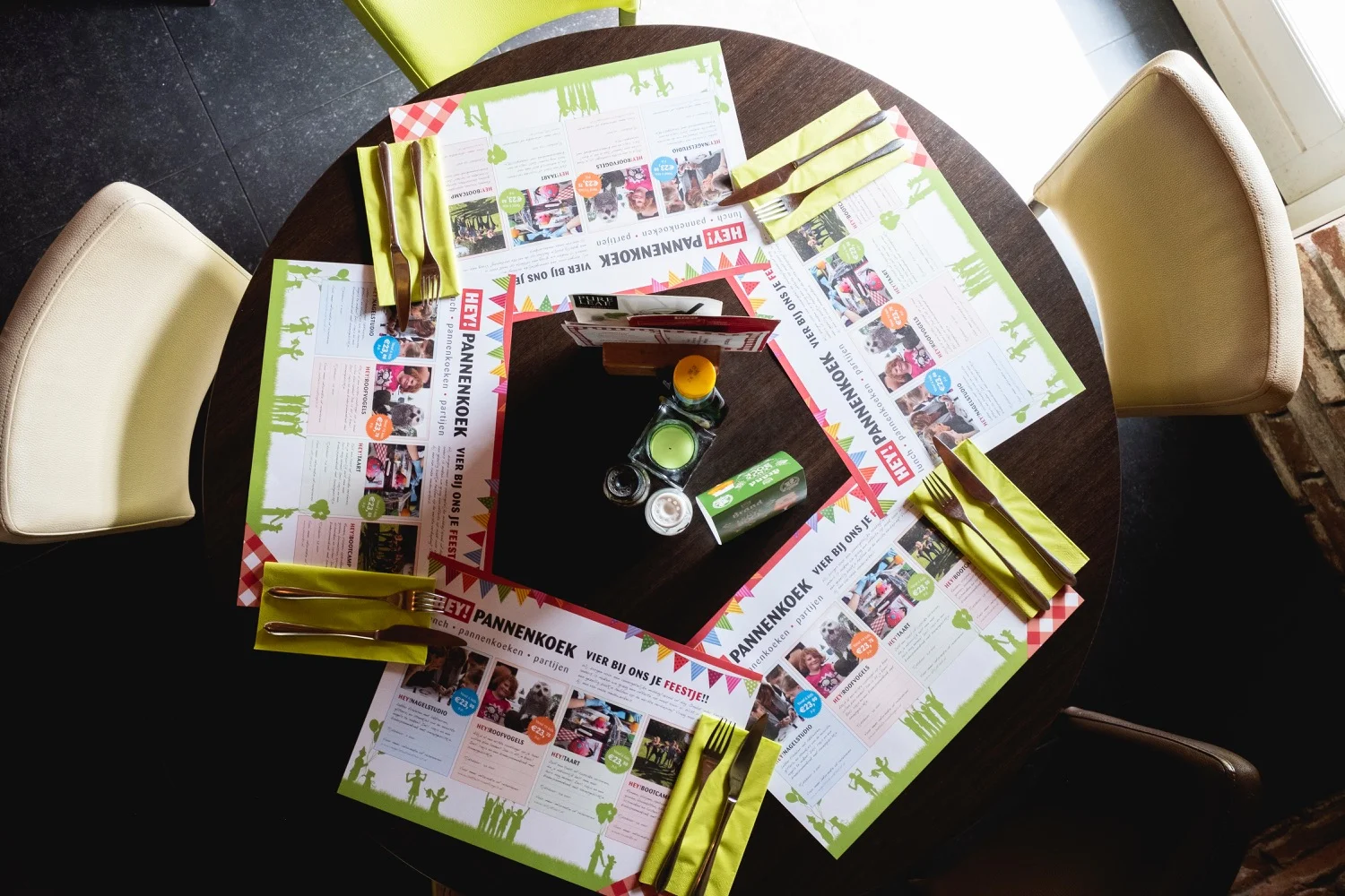 Ronde tafel van bovenaf met de HEY!-placemats klaargelegd